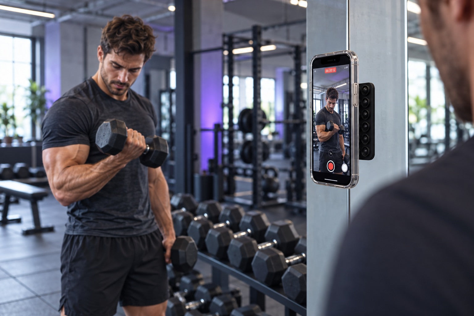 Un homme se filme avec un téléphone fixé au miroir d’une salle de sport